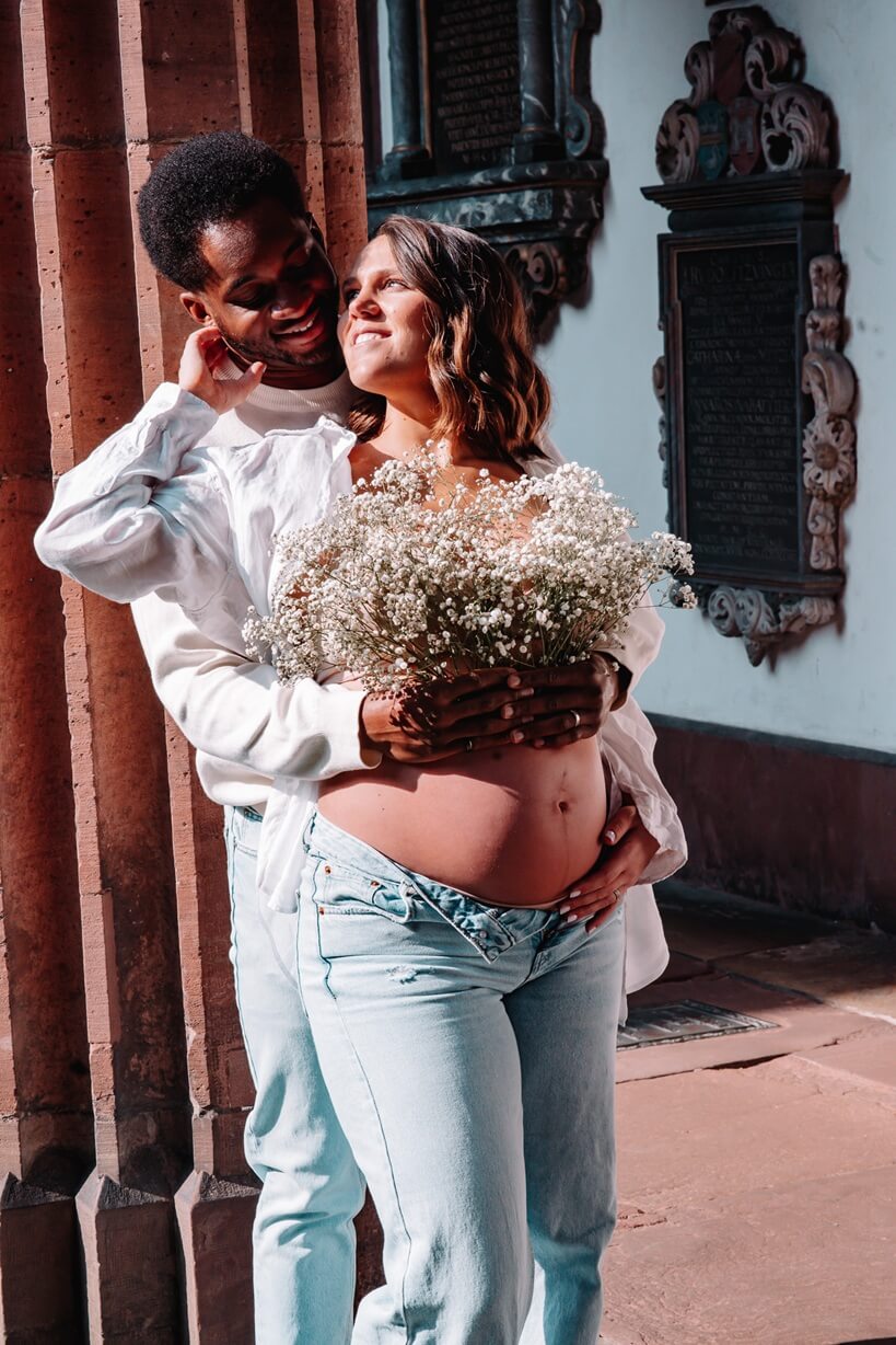 babybauchshooting-paar-sonnenlicht-blumenstrauss