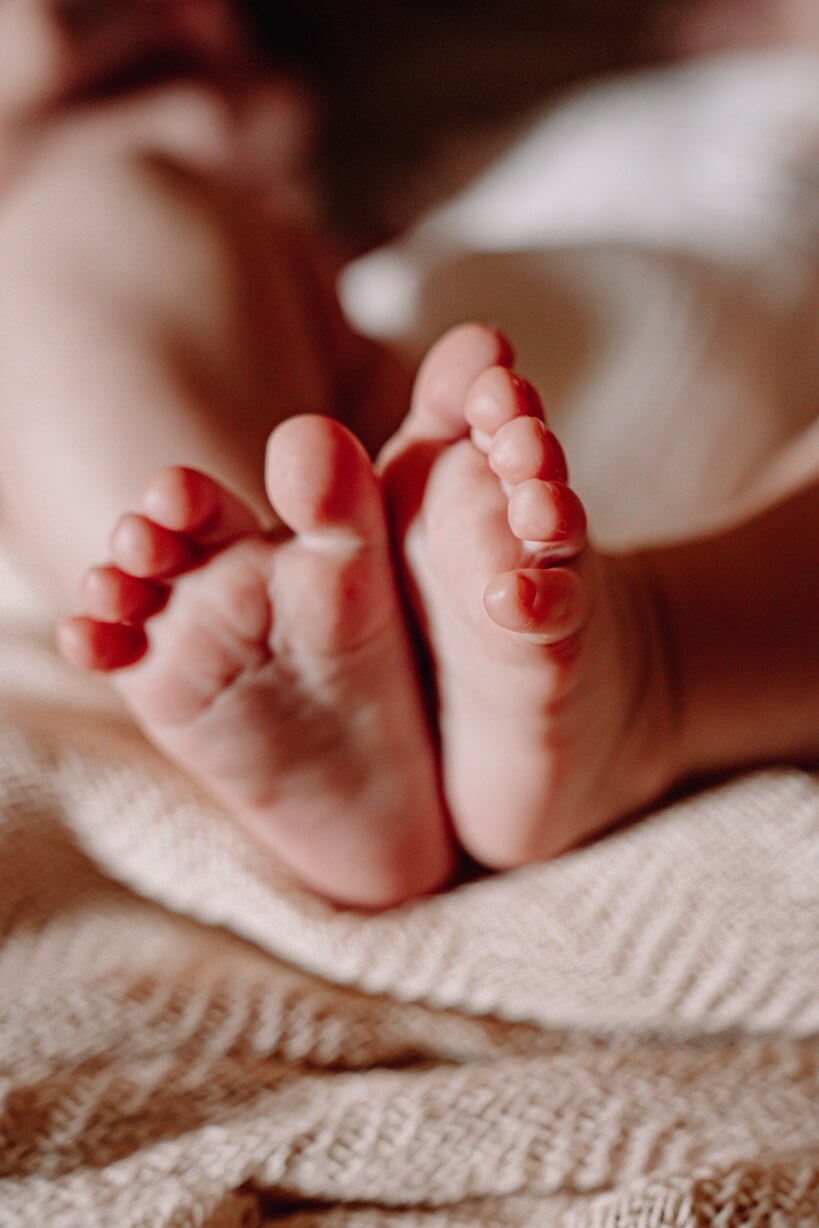 Newbornfotografie Fricktal – zarte Babyfüsschen in warmen Tönen